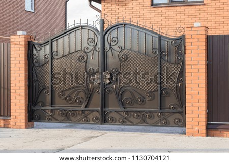 Beautiful automatic gate with forged elements in the family house
