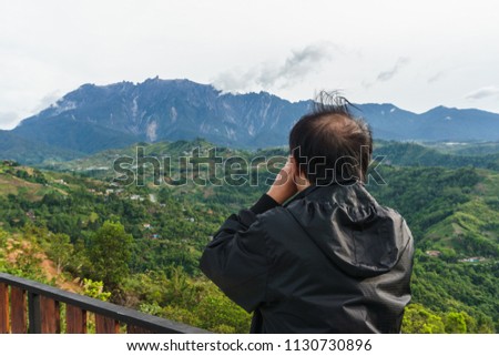 Asia man taking picture of beautiful Mount Kinabalu, Sabah, Borneo
