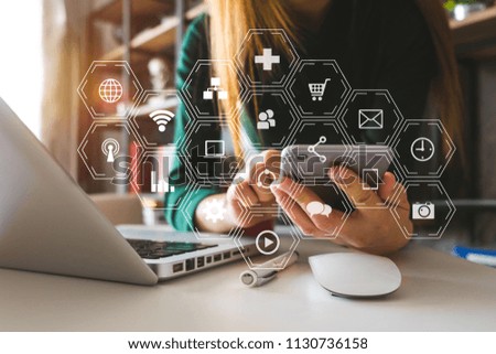  woman using smart phone for mobile payments online shopping,omni channel,sitting on table,virtual icons graphics interface screen in morning light
