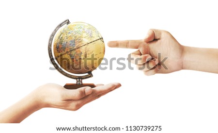 Human hand holding a globe isolated from a white background.