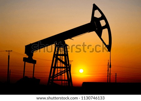 Crisis in the oil industry. The end of the era of oil deposits. Pump jack against the sun