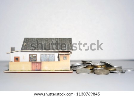 A miniature of house and coin showing that home financing is a serious matter in Malaysia.