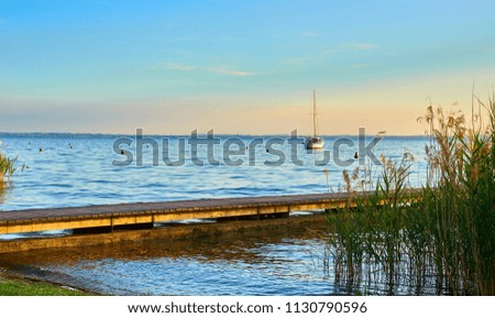 Long wooden pier at Lake Garda in Italy at sunset / slightley blurred picture with nice bokeh