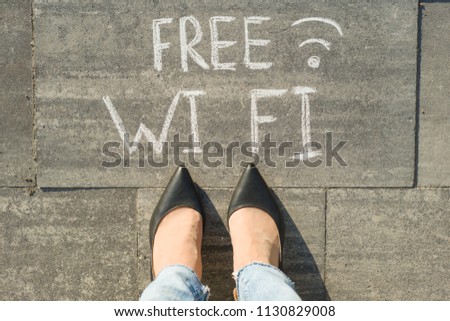 Female feet with text free wi fi written on grey sidewalk