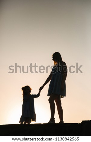 Silhouette of mother and little daughter
