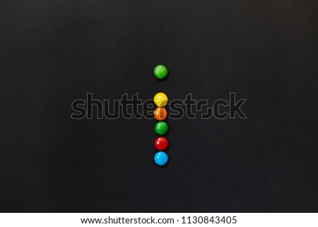 English Alphabet made of colored candies. The letter I. On a black background