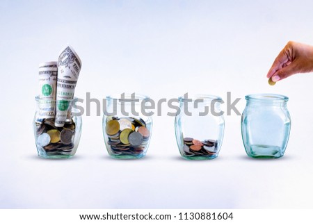 Saving  money. A hand putting money in bottle on White background. The coins in the bottle for save money. Photo financial saving and  Saving  money.