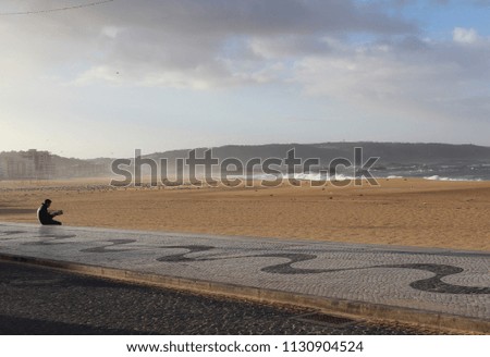 Scenic view of Nazare beach before the storm. Photographer makes the pictures of big waves. Cloudy weather.
