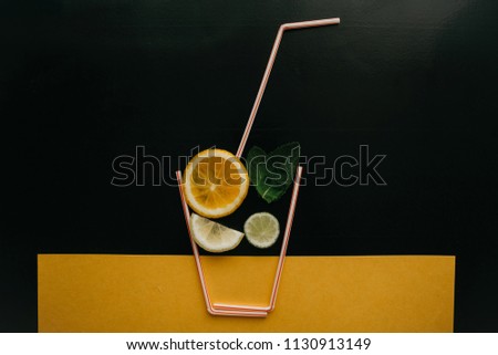 Conceptual photography. Citrus lemonade or juice from fresh fruits in a glass of tubules