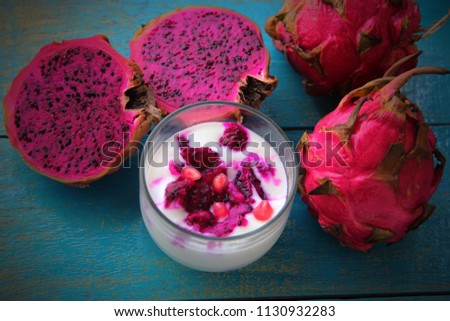 Dragon fruits on wooden background. The fruit has a soft texture and a sweet but unique flavor. It has a attractive color of skin full of edible flesh. This photo can use and food and drink background