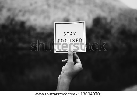 Hand holding stay focused text
