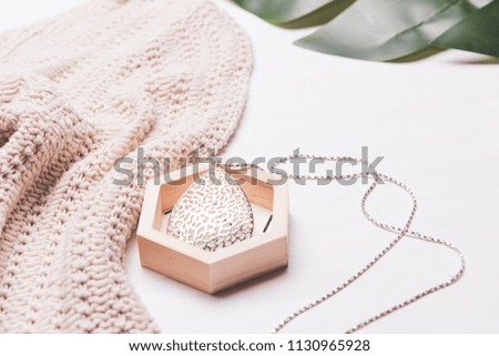 Female fashion concept. Simple design of beige color knitwear cloth for casual, with accessory on white background.