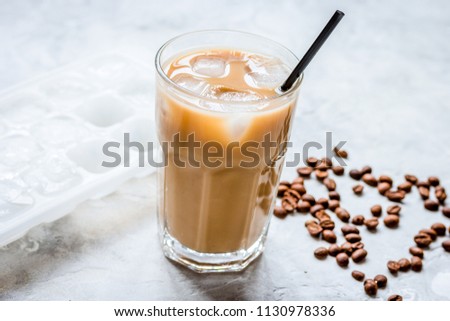 coffee ice cubes and beans with latte on stone desk background