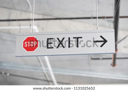 Grey metallic stop and exit sign with arrow.