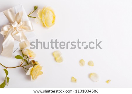 Festive flower yellow English rose and gift box with ribbon composition on white background. Overhead top view, flat lay. Copy space. Birthday, Mother's, Valentines, Women's, Wedding Day concept.