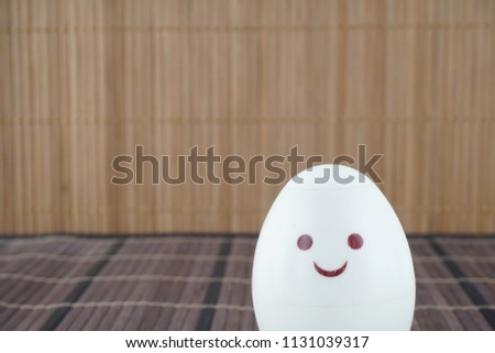 painted eggs with a smiling face over the wooden background