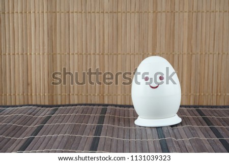 painted eggs with a smiling face over the wooden background