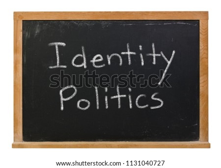 Identity politics written in white chalk on a black chalkboard isolated on white