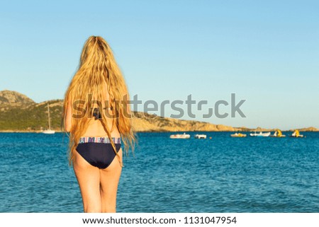 woman with long blond hair on the beach at sunset