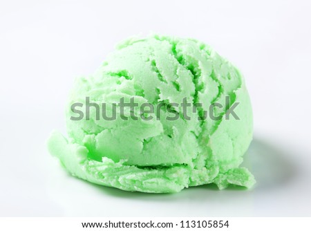 Scoop of green ice cream on white background