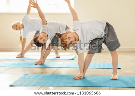 Little children practicing yoga indoors Royalty-Free Stock Photo #1131065606