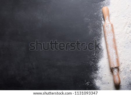 Baking background with copy space on black surface for your text. Top view. Flour is a traditional ingredient for breadmaking and other baking. Often used in Italian, Arabic and Chinese cuisines Royalty-Free Stock Photo #1131093347