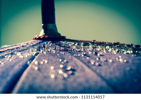 Raindrops on a colorful umbrella with all the colors of the rainbow close-up macro waterdrops background. Vintage, grunge, old, retro style photo.