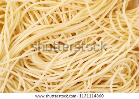Surface coated with the cooked noodles, close-up fragment as a backdrop texture compositions