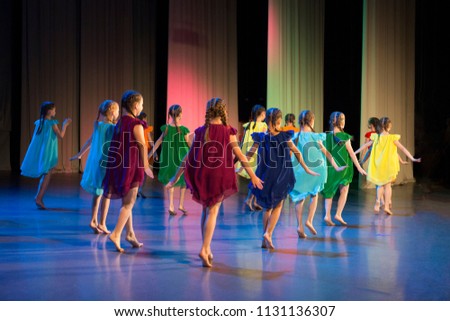 Girls dance on stage in colorful dresses. Royalty-Free Stock Photo #1131136307