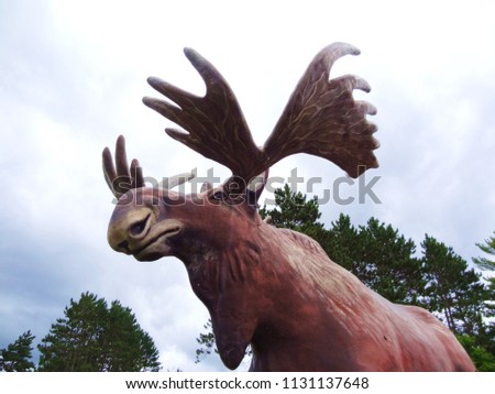 picture of large fiber glass moose of sky above symbol of the Northwood country travel