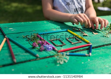 the child draw picture with colorful pens and flowers on the wooden green table in the nursery or school for activity concept. creative ideas for child development.