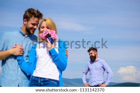 Ex partner watching girl starts happy love relations. New love. Couple in love dating outdoor sunny day, sky background. Couple with flowers bouquet romantic date. Ex husband jealous on background. Royalty-Free Stock Photo #1131142370