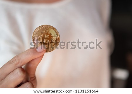 Closeup of female hand showing gold bitcoin