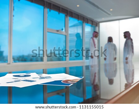Saudi Arab businessmen talking in a meeting room, focus on ducuments on the table Royalty-Free Stock Photo #1131155015