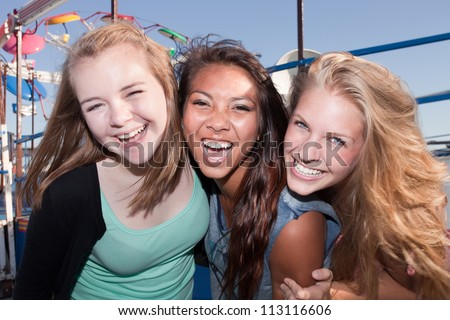 Three Asian and white teenage friends laughing together