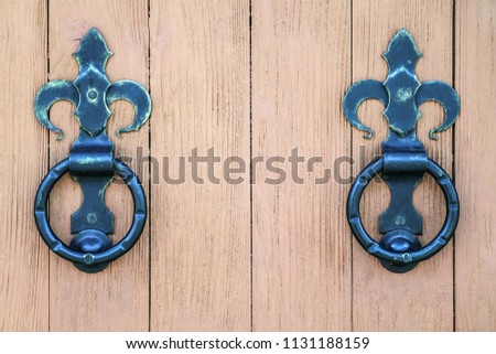 Ancient wooden gate with two door rings. The gate is closed