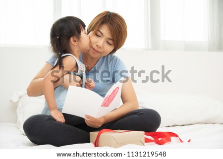 Happy mother's day. Asian Little girl kissing her mom.