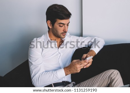Young hipster guy casual dressed reading email from friend in social networks and creating publication for own blog, indian man searching information for attracting followers in content web page