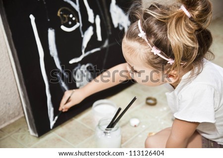 A child draws a picture of acrylic