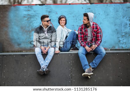 Three friends are having fun at the skateboard ramp.