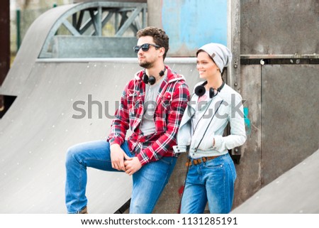  young couple listening to music in a skate park