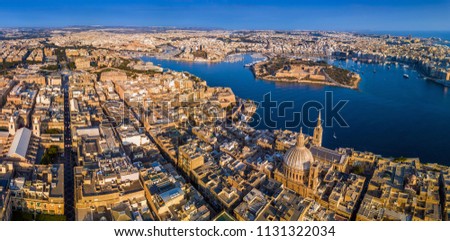 Valletta, Malta - The capital city of Malta from above on a panoramic shot with Our Lady of Mount Carmel church, St.Paul's Cathedral and Manoel Island at sunrise