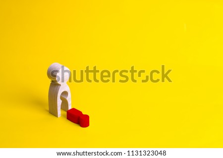A wooden figure of a woman with a void from which a red child fell. The concept of the loss of a child, abortion of pregnancy, miscarriage. mother lost her child. Deprivation of parental rights. Royalty-Free Stock Photo #1131323048