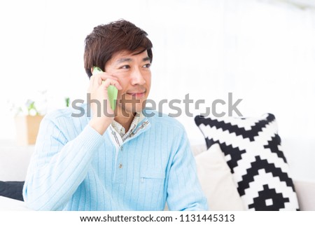 Asian middle age man who talks on the telephone