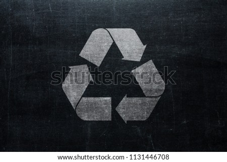 Recycle sign on chalkboard isolated on blackboard texture with chalk rubbed background from top view. Recycling infographic element