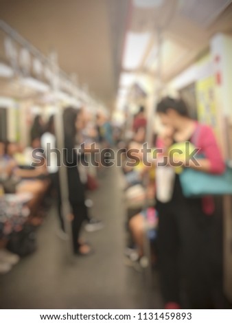 Blurred image abstract background of city people lifestyle inside the train standing walking and sitting using internet with smartphone or mobile phone on the way go to work in the morning.