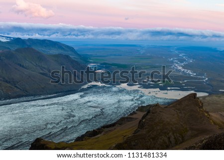 Aerial view of moraine glacier river in South Iceland. Sunset scene, meandering river net with white clouds in the horizon. Shot from Kristinartindar mountain.