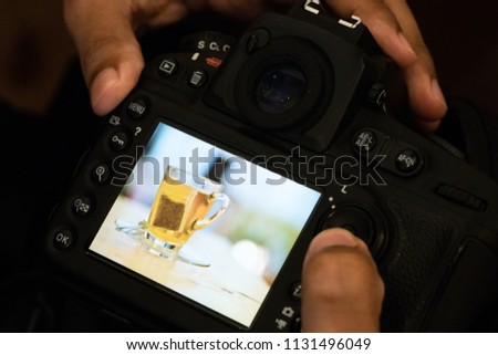 professional photographer take photo and check image tea bag photo on back  camera monitor.scan and check photo behind camera monitor view image