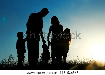 silhouette of a happy family with children on sunset