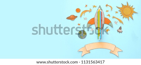 Back to school banner. rocket cut from paper and painted over wooden blue background